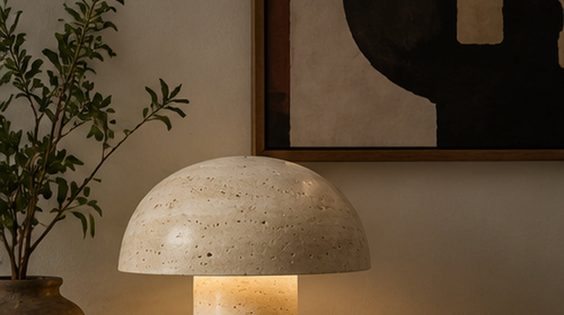 Travertine mushroom table lamp glowing warmly on a console table beside a plant and abstract wall art