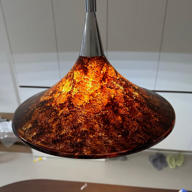 Amber glass pendant light on a white wall background