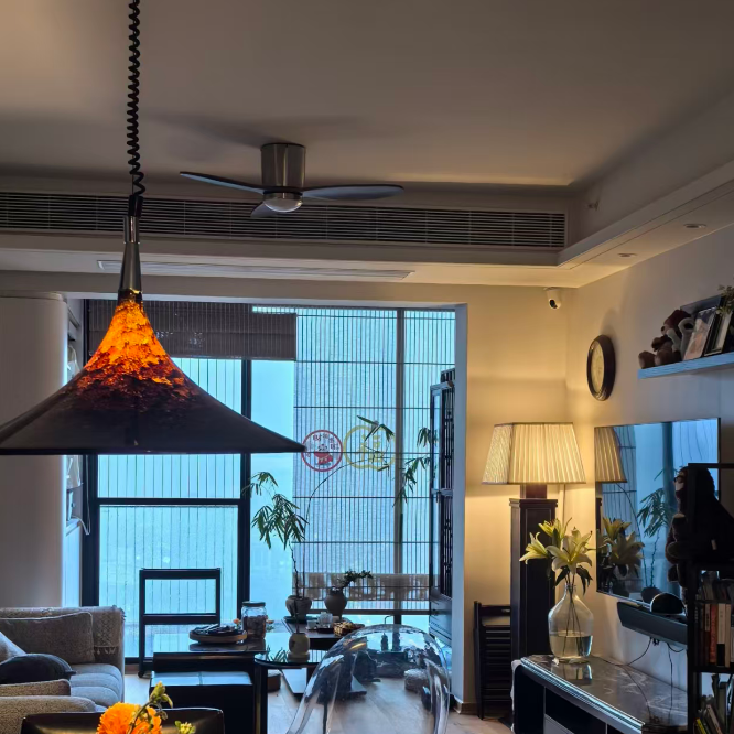 Modern living room with a round table, chairs, and decorative elements.