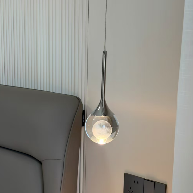 Modern wall-mounted light fixture on a neutral wall next to a gray sofa.