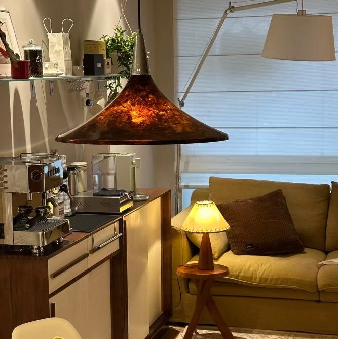 Modern kitchen with a dining area, featuring a stove, sink, and a view of a living room.