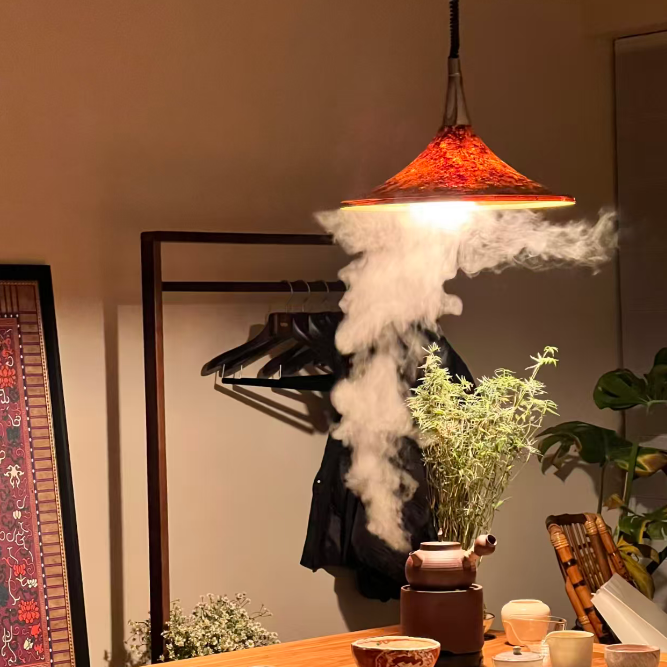Wooden table with tea set, plant, and hanging jacket with steam in a room.