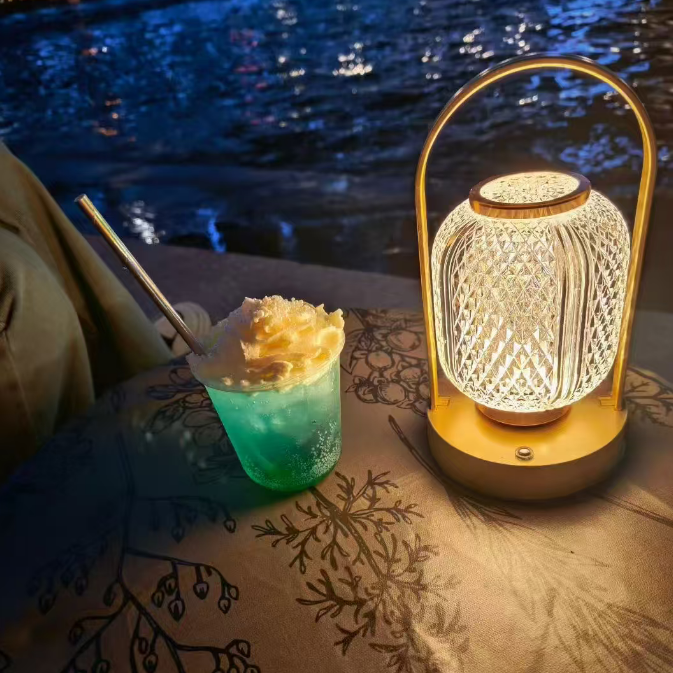 Decorative lamp on a table by a body of water at night