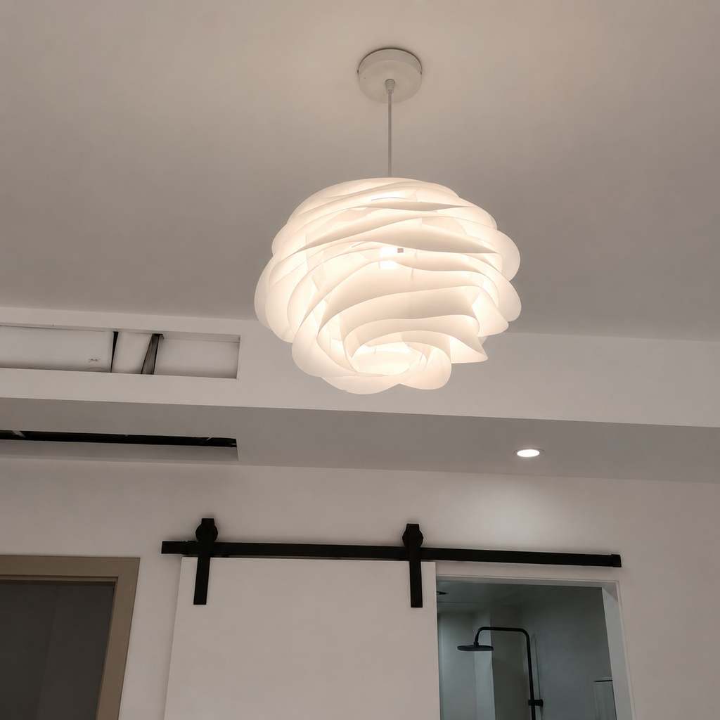 Modern ceiling light fixture in a room with white walls and a sliding door.