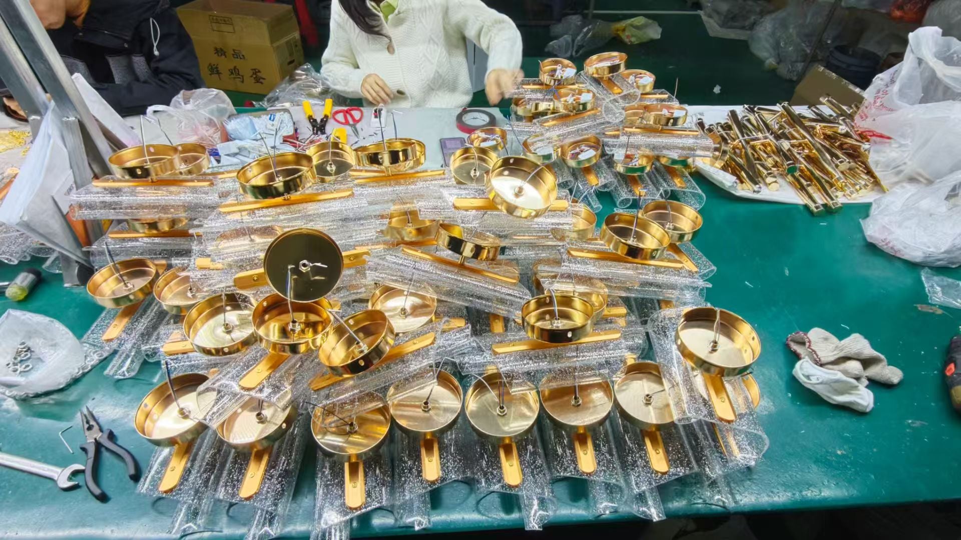 Lighting components being assembled by hand at a workshop table