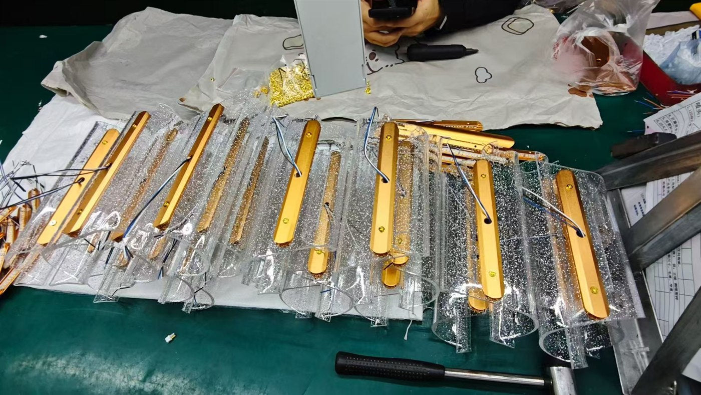 Gold linear lighting parts arranged on a workshop table